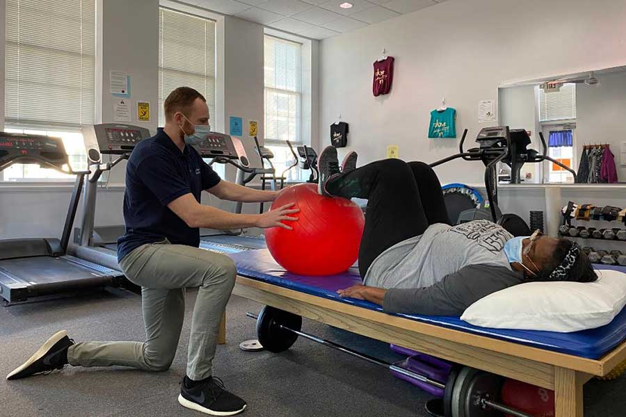 Ben showing a patient physical therapy exercises with an exercise ball | La Plata Physical Therapy in La Plata, MD
