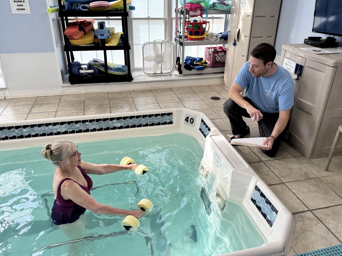 Physical therapy assistant teaching a patient about aquatic therapy at La Plata Physical Therapy and Wellness in La Plata, MD